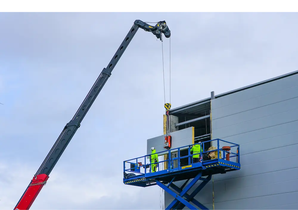 Engineers working on construction site and fixing sandwich panels for walls